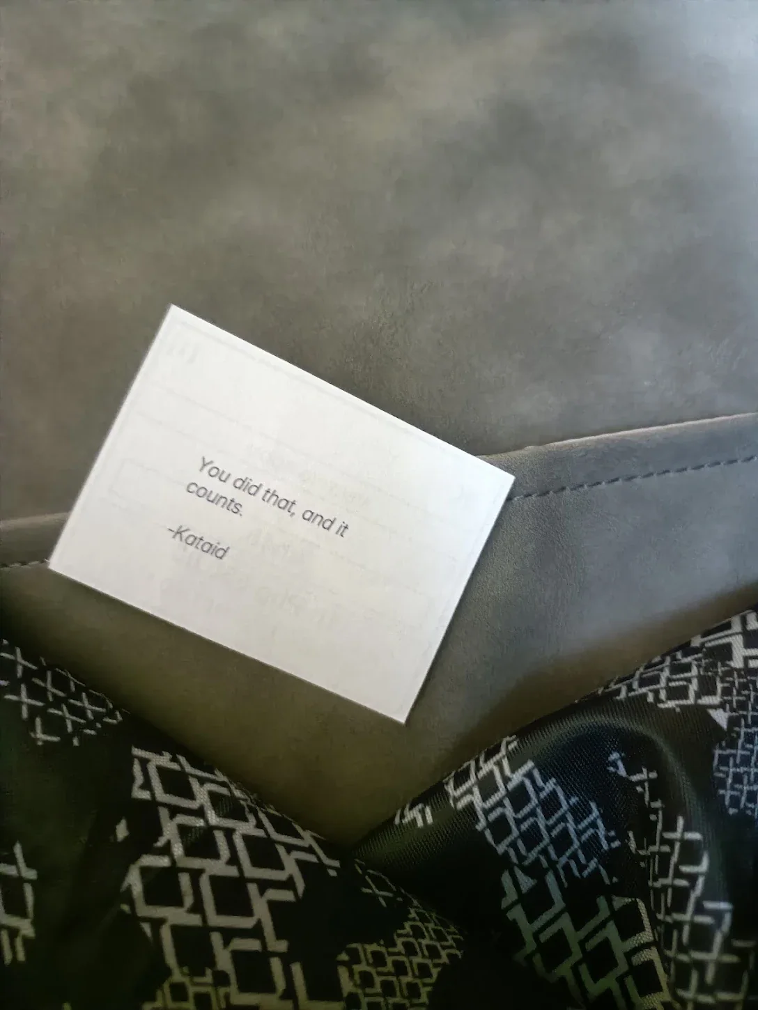 A Kataid WiFi card that reads You did that, and it counts, resting on a guest's bag.